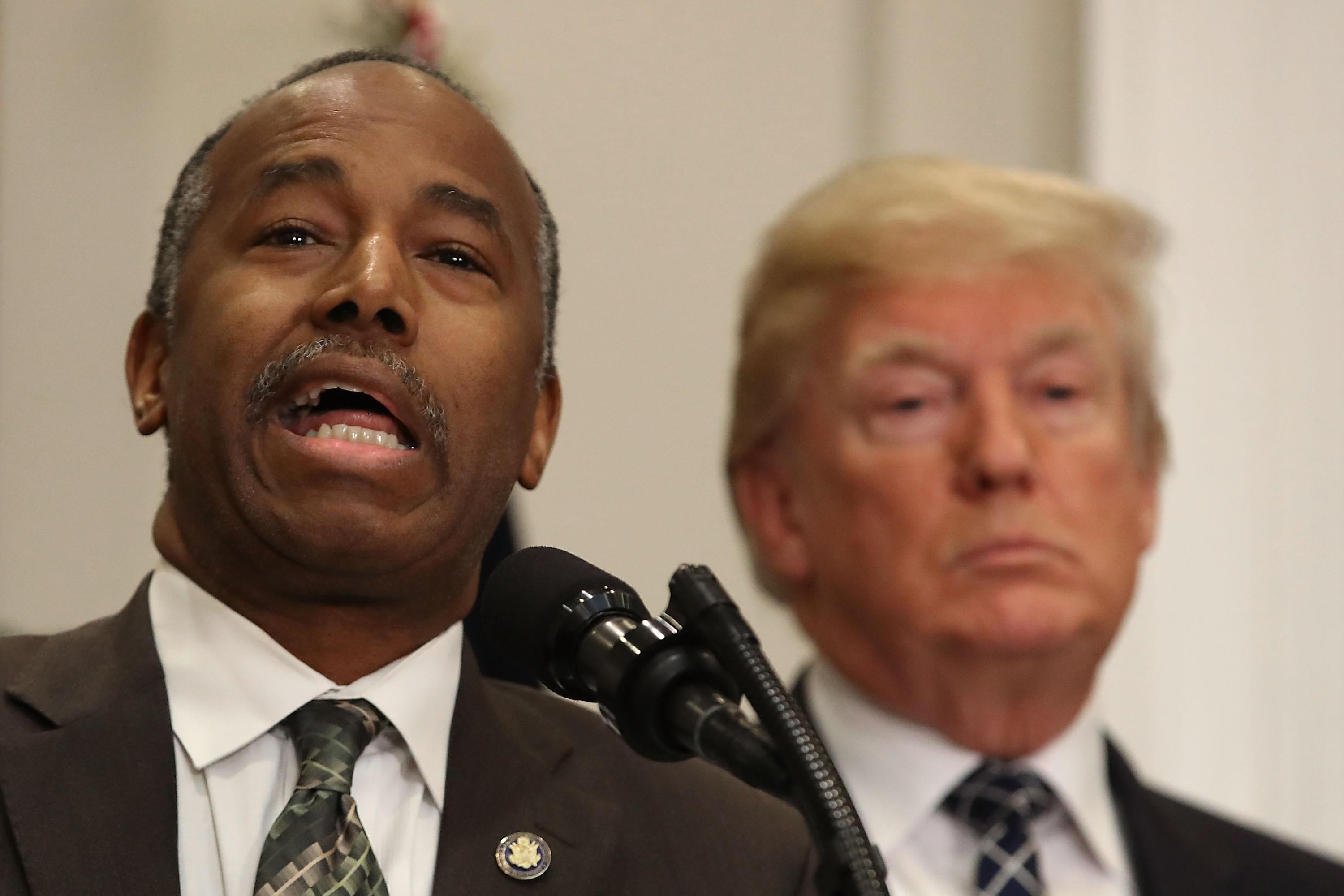 HUD Secretary Ben Carson, with Donald Trump in the background.