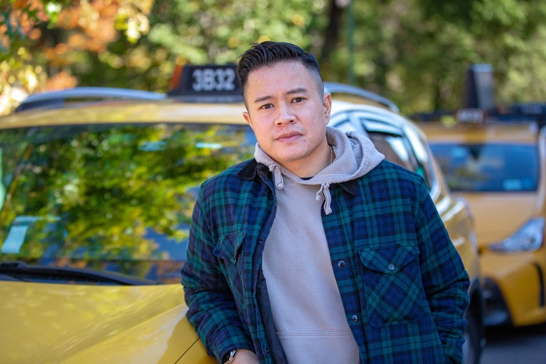 Augustine Tang next to his cab.
