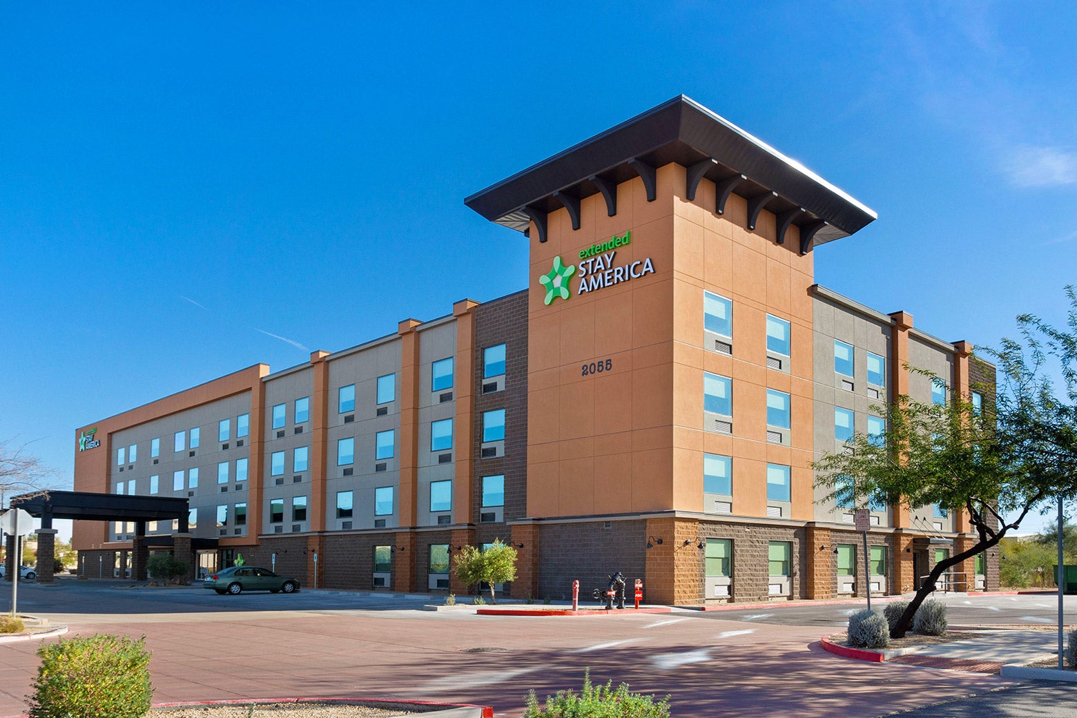 An exterior view of an extended-stay hotel, with a parking lot.