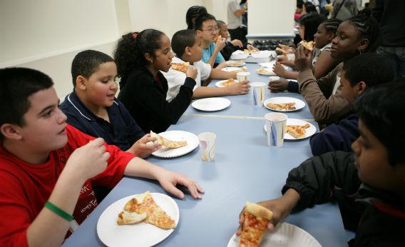 Kids eating pizza.
