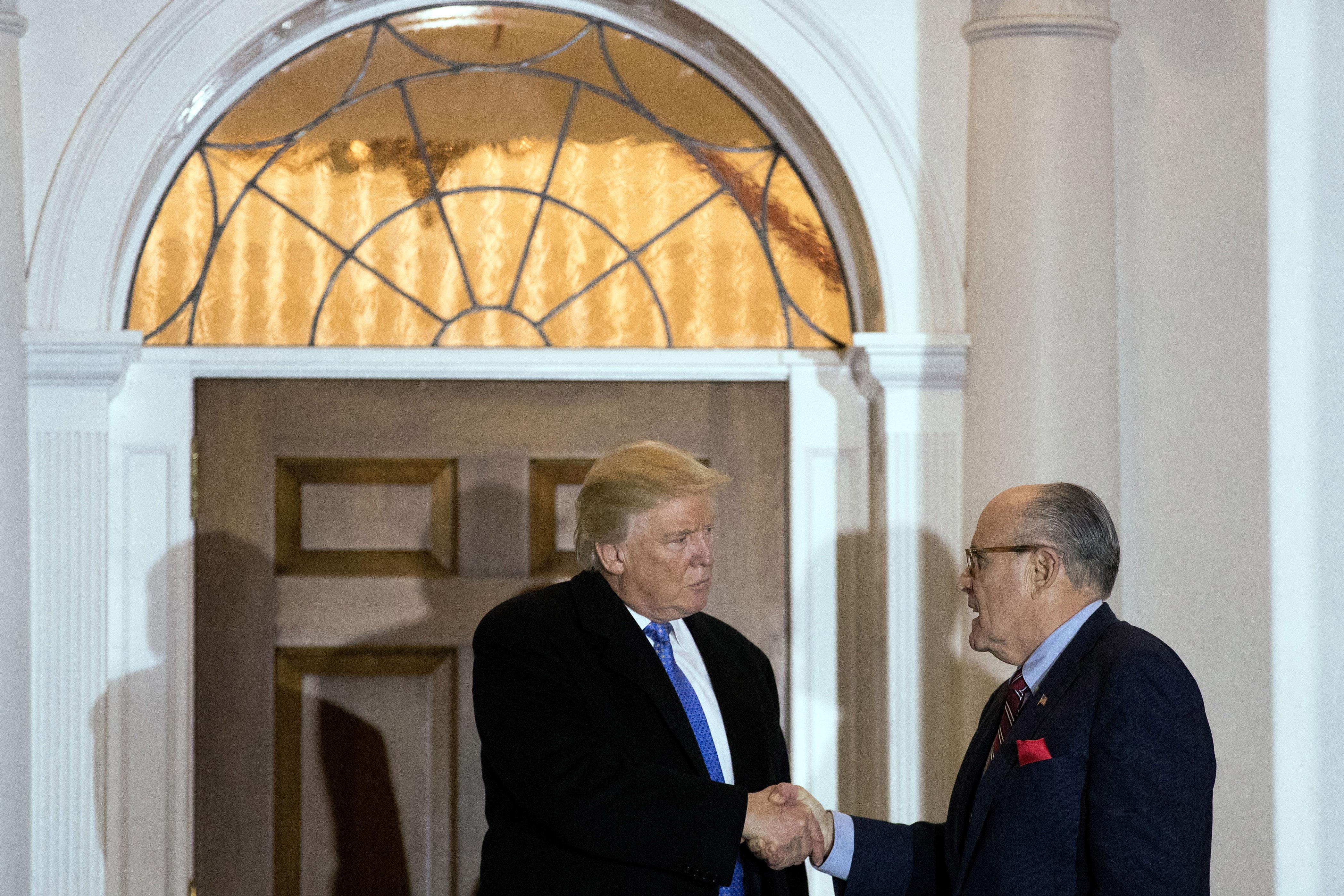 Donald Trump and Rudy Giuliani shake hands a meeting at Trump International Golf Club, November 20, 2016 in Bedminster Township, New Jersey. 