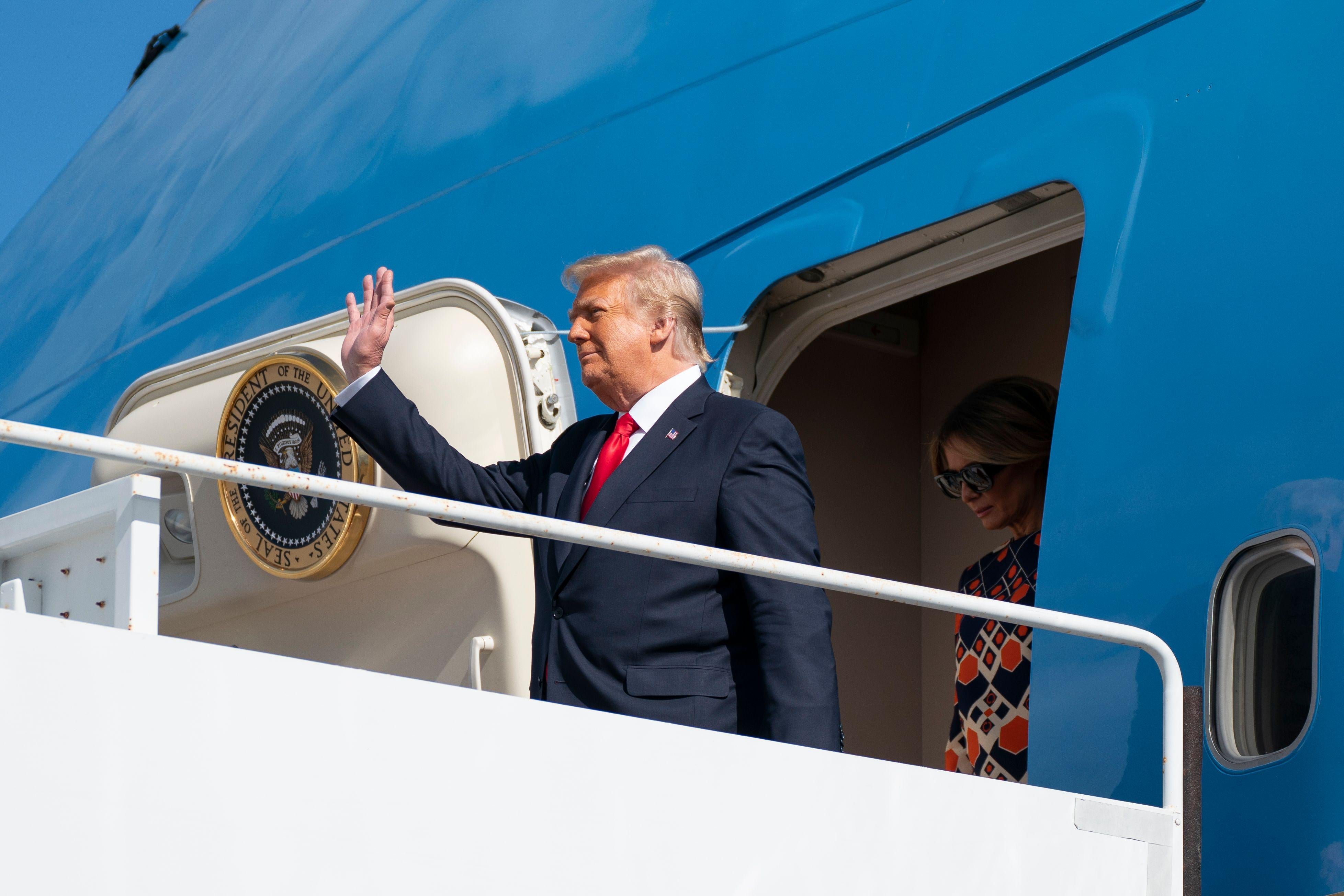 Donald Trump waves from the door of Air Force One.