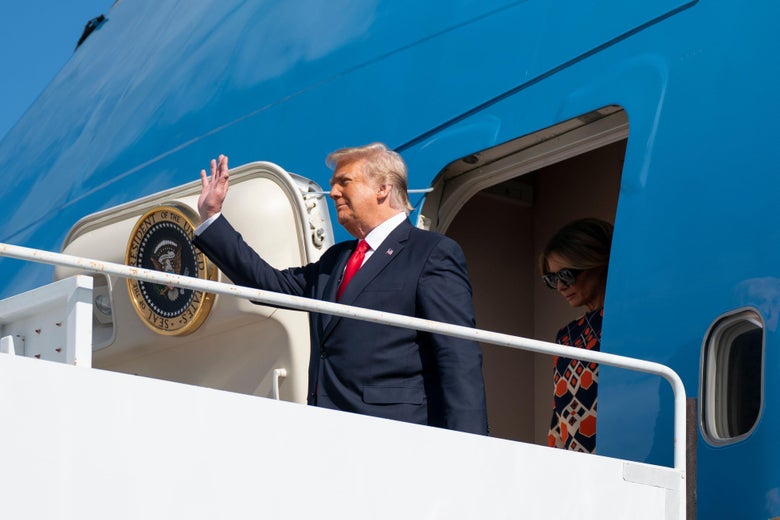 Donald Trump waves from the door of Air Force One.