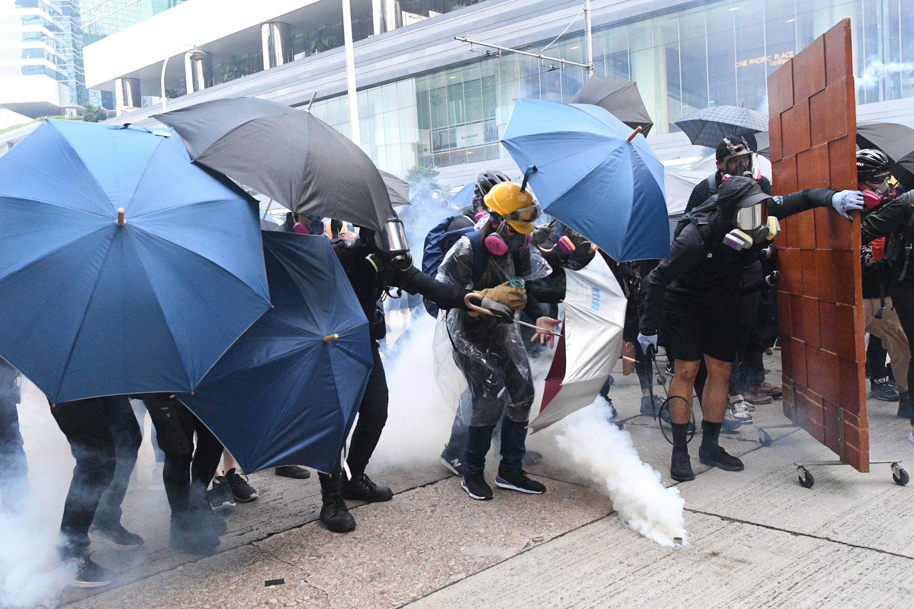 Protesters react after Hong Kong police fire tear gas on a street.