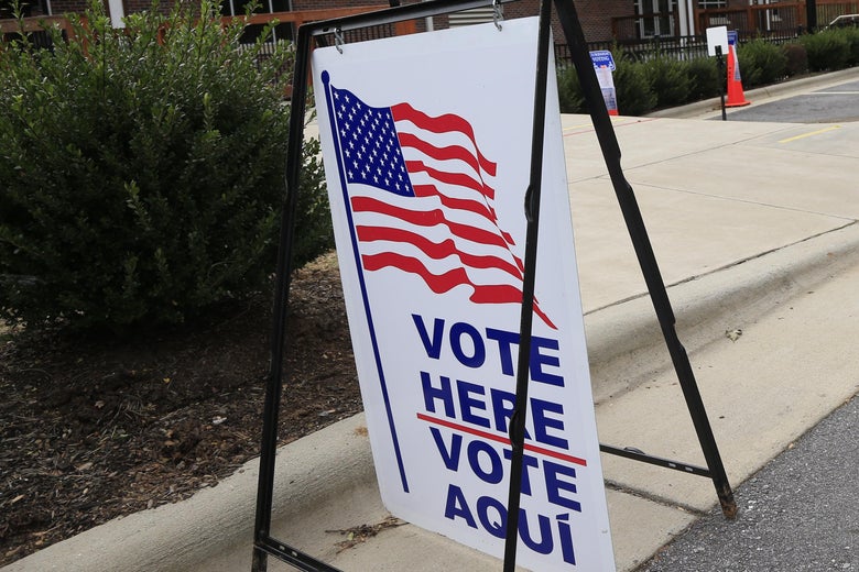 A "Vote Here" sign next to a curb