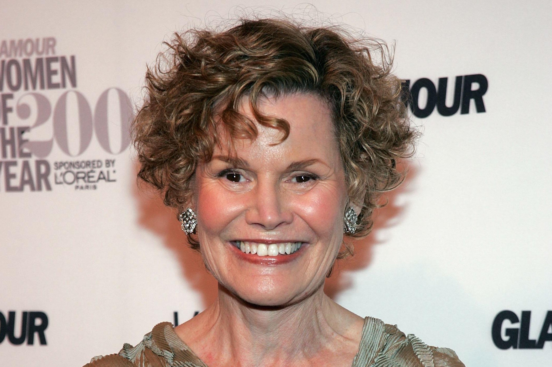 Judy Blume on a red carpet, smiling.