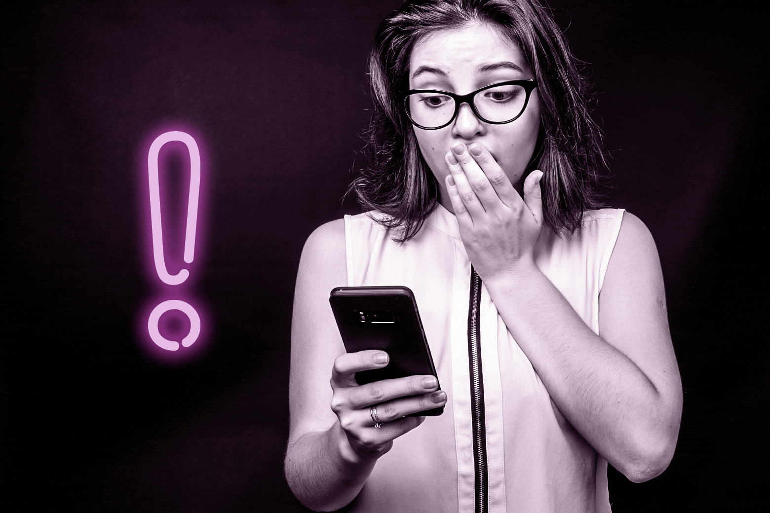 A woman looks shocked at her phone.