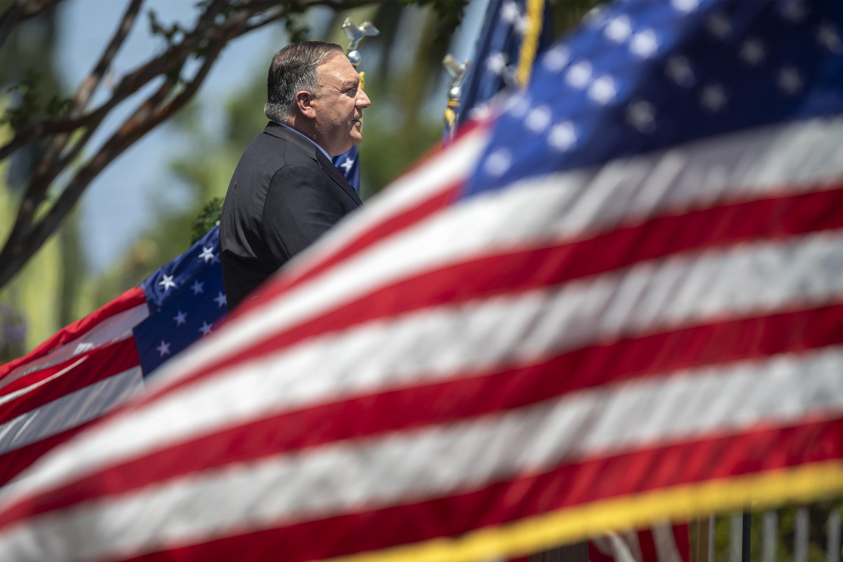 Mike Pompeo surrounded by American flags.