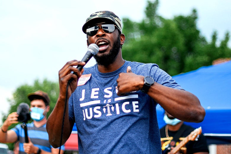 Jonathan Tremaine Thomas, wearing sunglasses, speaks into a microphone.
