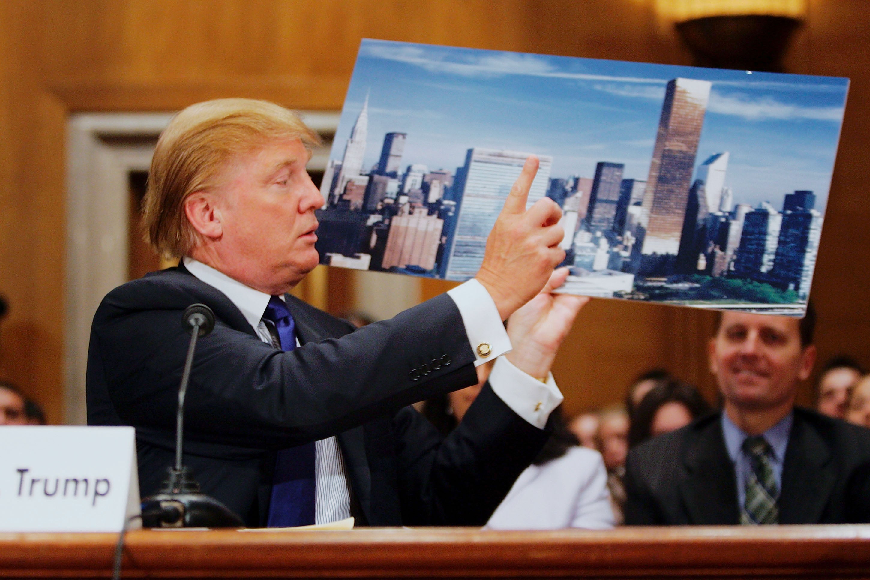 Donald Trump with a photo of the Trump World Tower, where the individual attesting to his alleged affair once worked, in Washington D.C. in 2005.