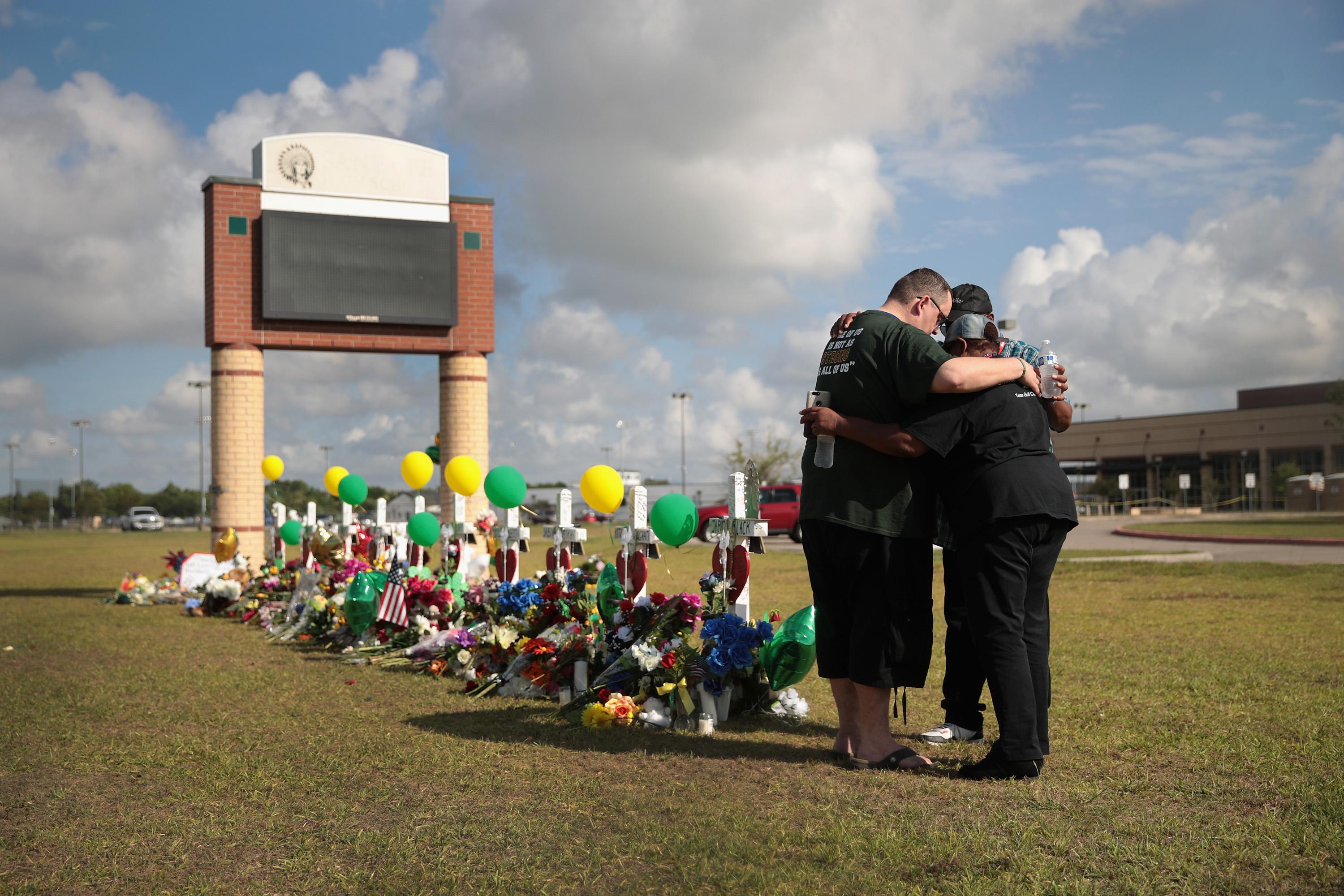 Mourners pray at a memorial in front of Santa Fe High School on May 22, 2018 in Santa Fe, Texas. 