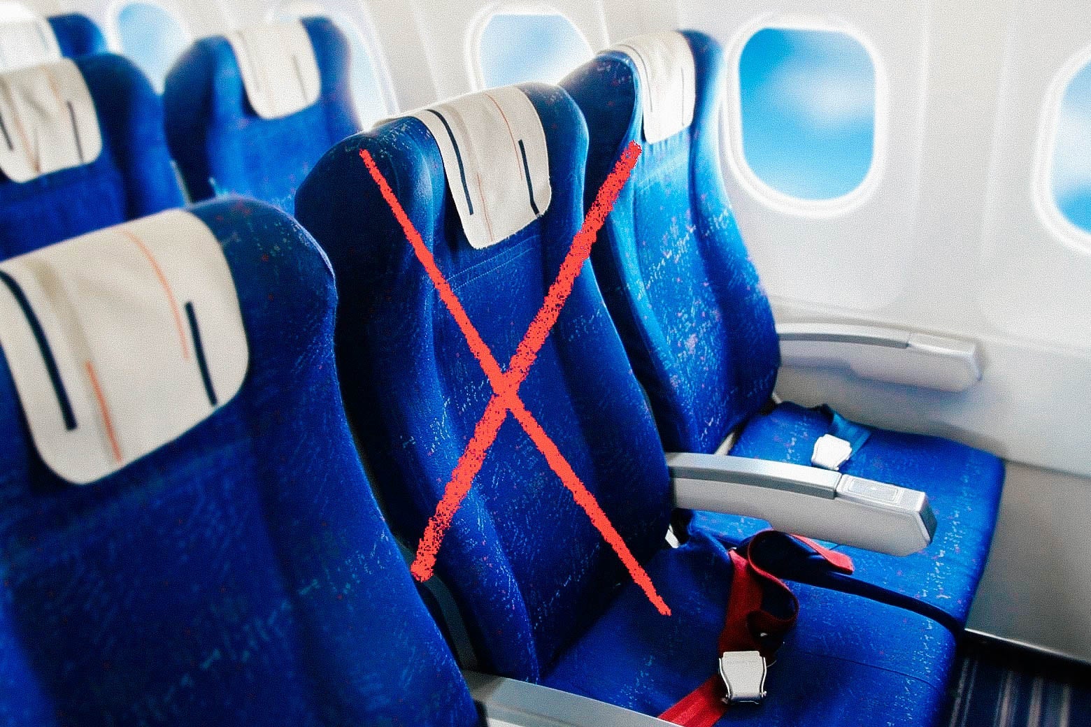 A row of seats on an airplane with the middle seat crossed out