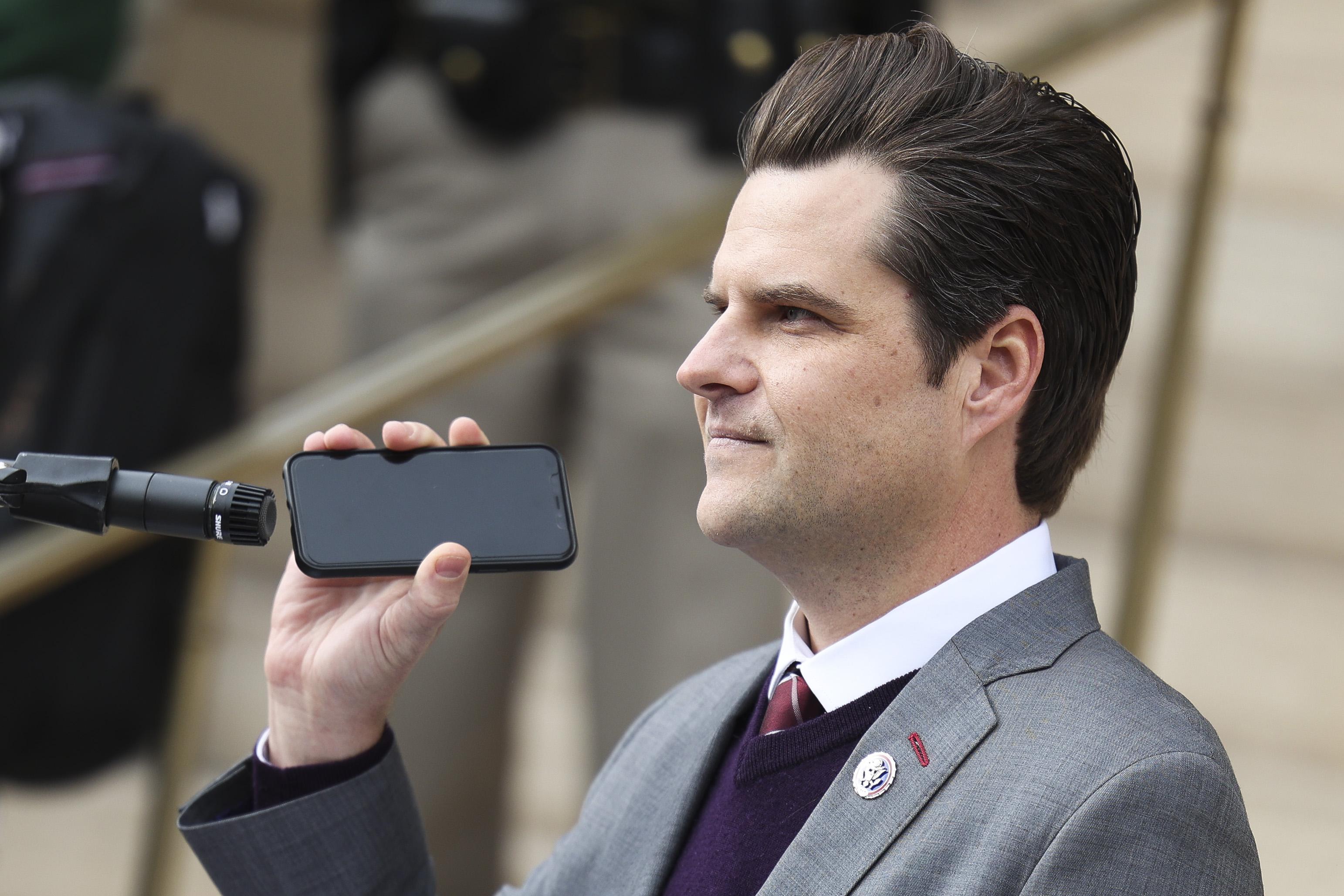 Rep. Matt Gaetz holds a phone to the microphone as Donald Trump Jr. speaks remotely to a crowd during a rally against Rep. Liz Cheney (R-WY) on January 28, 2021 in Cheyenne, Wyoming.