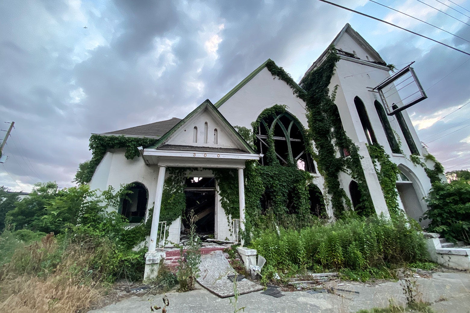 An abandoned church with ivy growing up the sides.