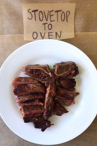 A T-bone steak on a plate next to a sign labelled "Stovetop to Oven."