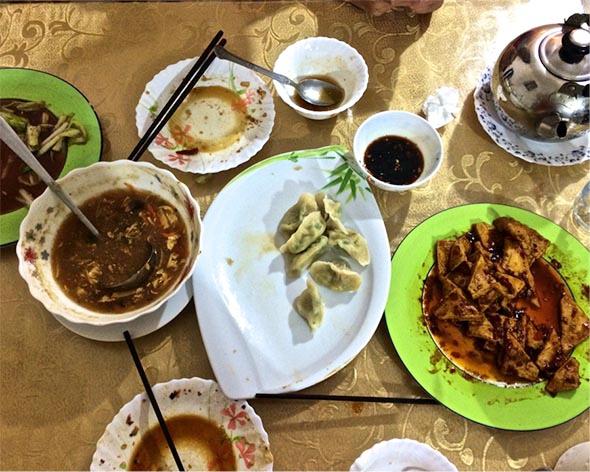 Hot and sour soup, chive and egg and meat dumplings, bok choy, home-style tofu, green tea, and emptied plates at Ruyi Fang off a side street in Maadi. 