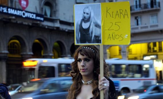A transsexual person displays a poster with the picture of a transsexual person who was murdered.