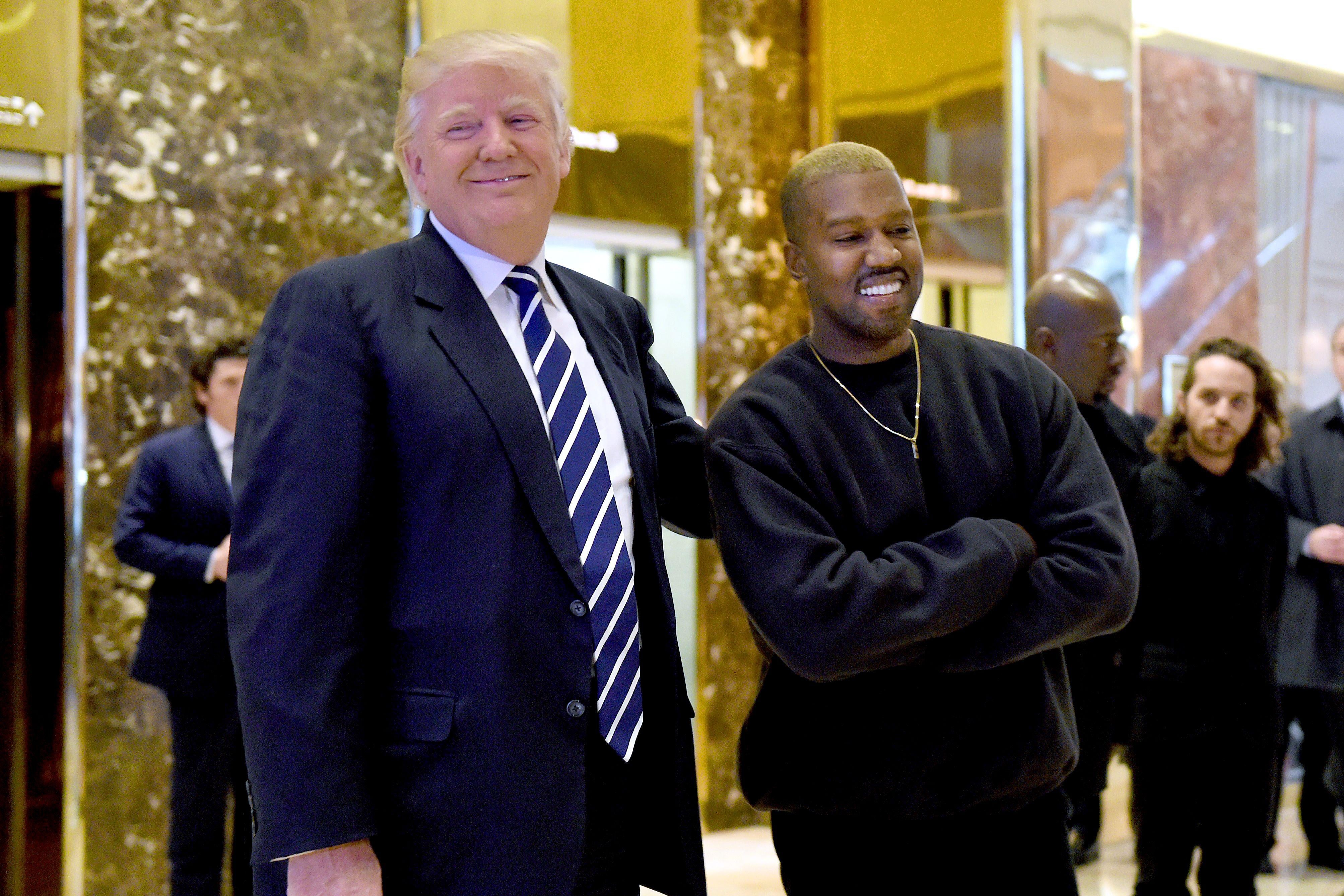 Donald Trump and Kanye West pose for a photo in the lobby of Trump Tower.