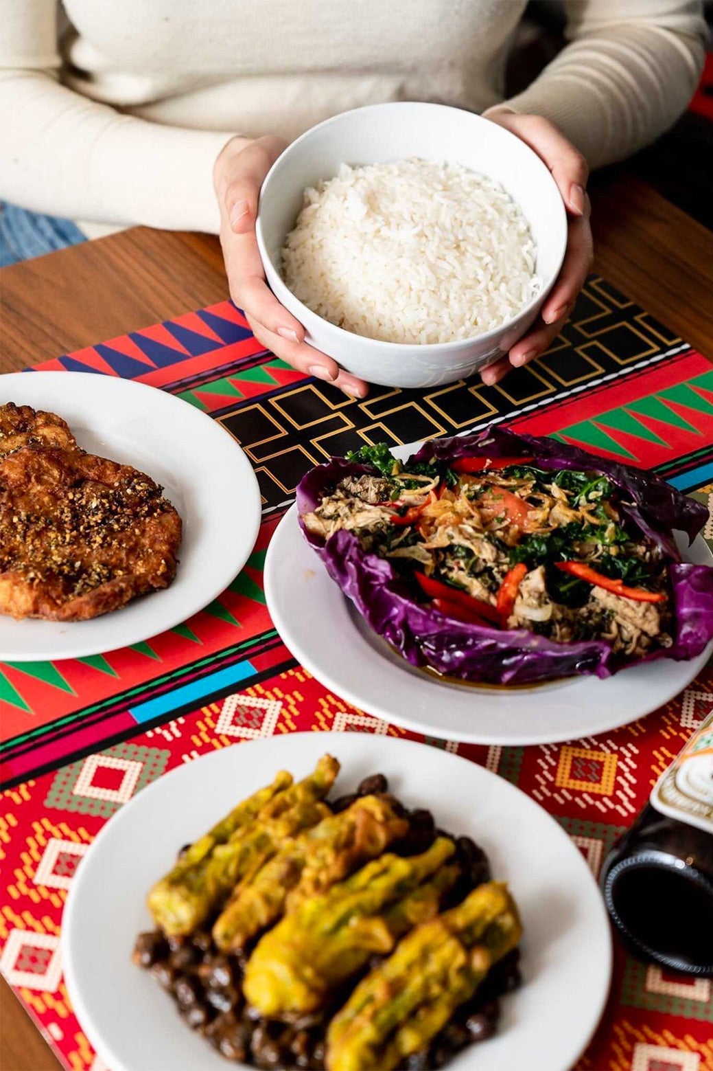 Dishes on top of a colorful place mat.