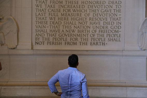 A tourist pauses in the Lincoln Memorial to read the Gettysburg Address.