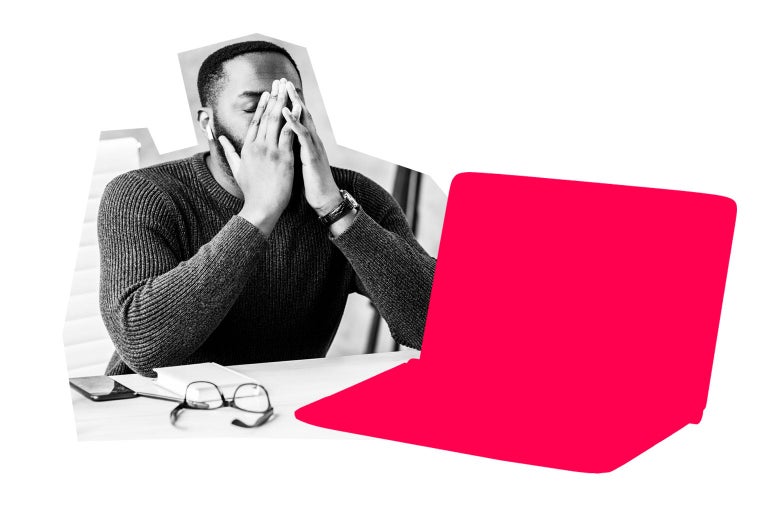 A man sitting in front of his laptop, covering his face with his hands in exasperation.