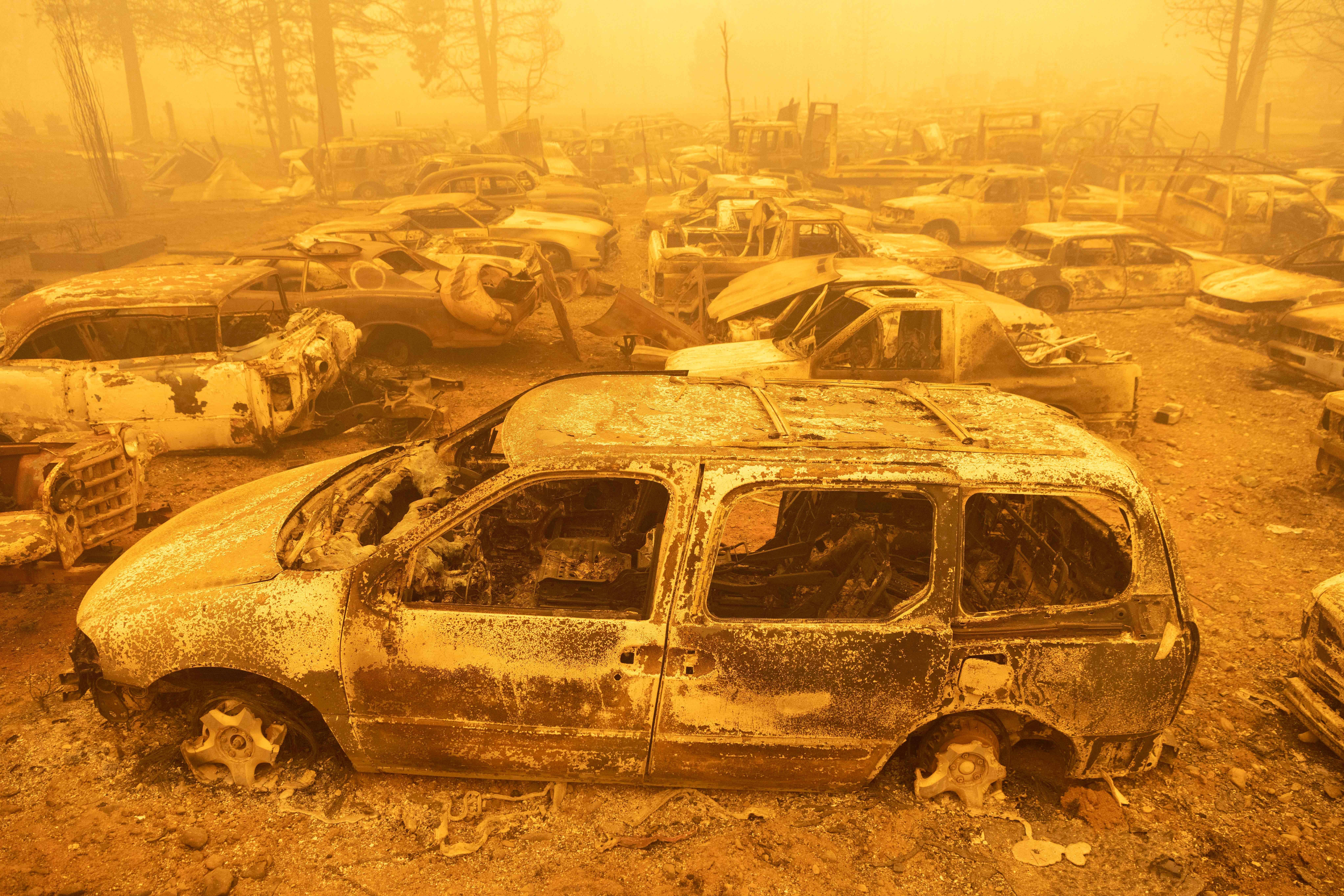 Dozens of burned vehicles rest in heavy smoke during the Dixie fire in Greenville, California on August 6, 2021. 