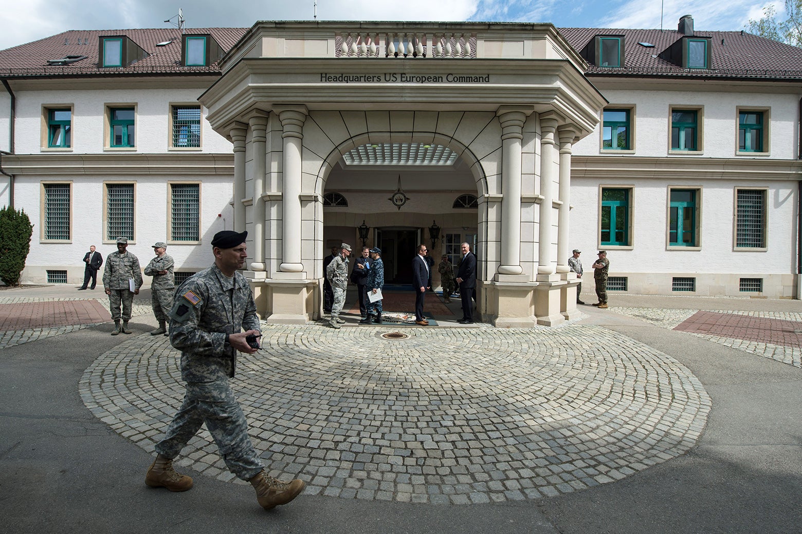 Members of the U.S. Armed Forces walk past a headquarters in Germany.