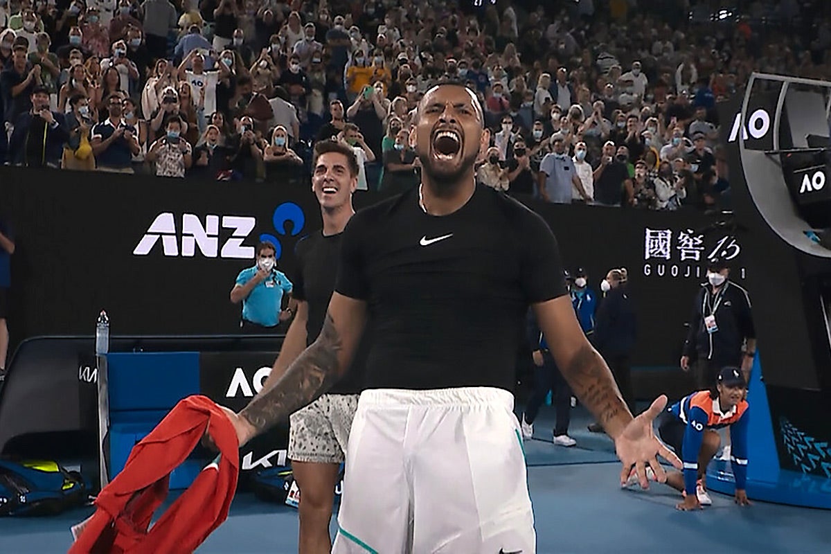 Kyrgios screams on the court with arms out wide, crowd going wild behind him