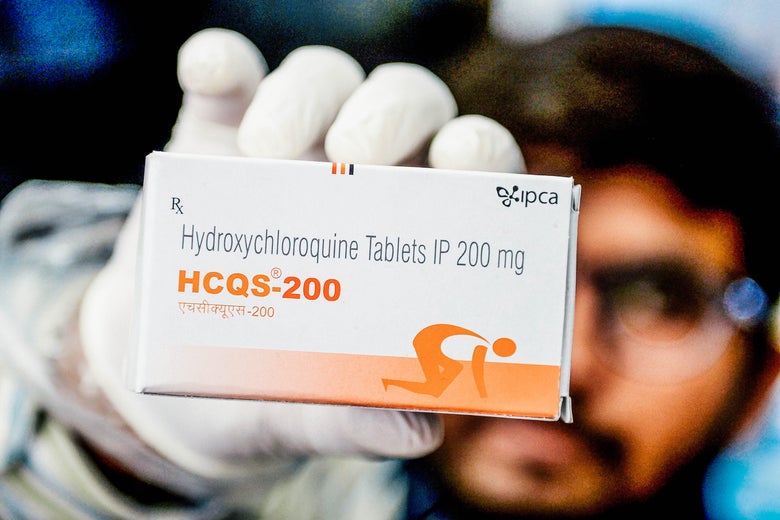 A man holds up a box of hydroxychloroquine tablets.