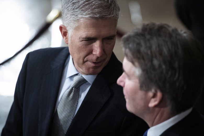 Gorsuch leans in to speak to Kavanaugh.