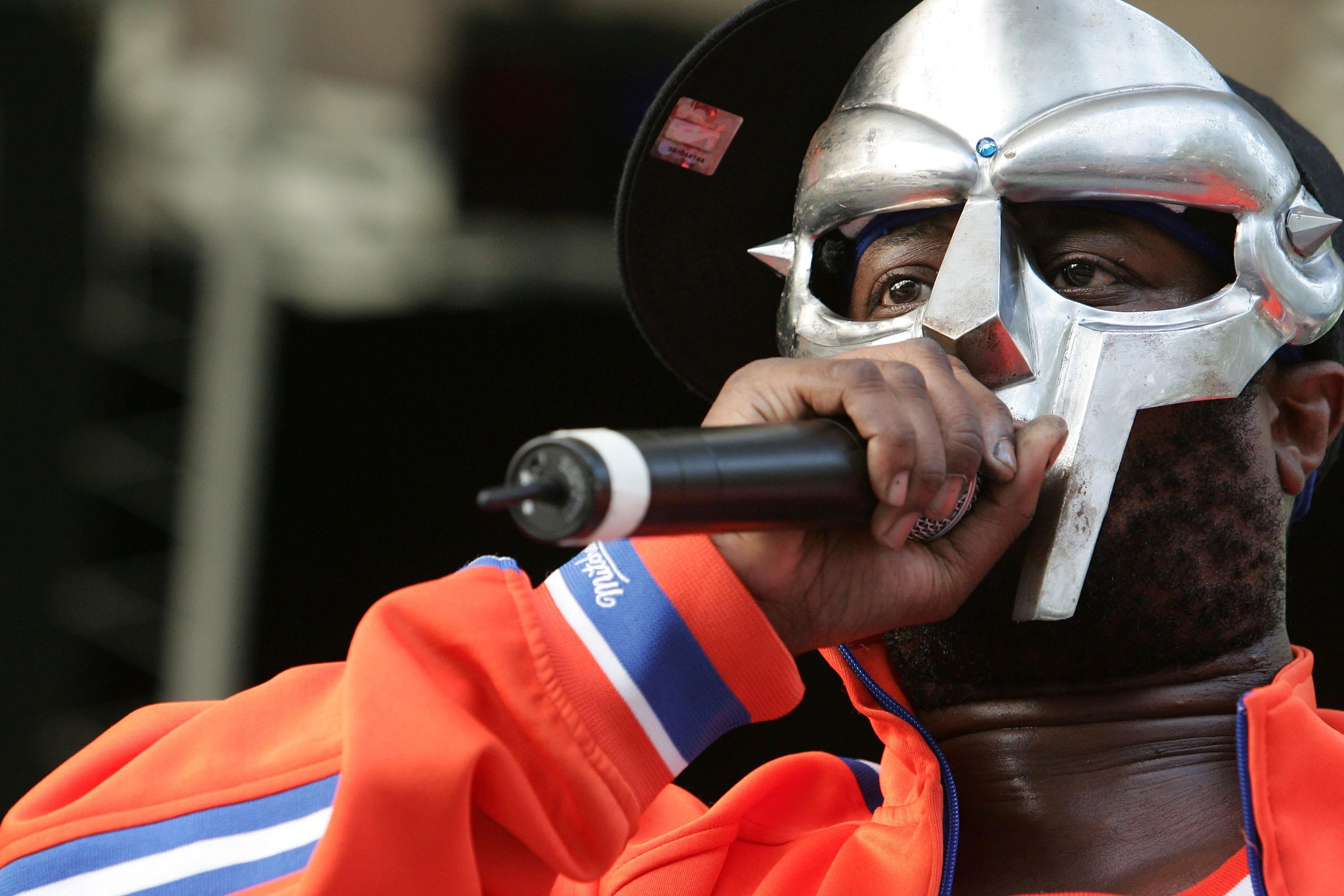 MF DOOM raises a mic and dons a Knicks Jersey, his face hidden behind his metal mask.