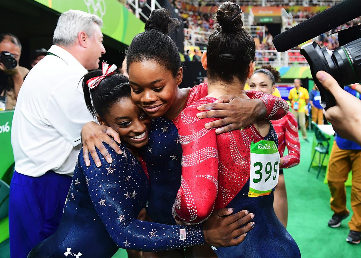US gymnast Simone Biles, US gymnast Gabrielle Douglas and US gymnast Alexandra Raisman embrace during the qualifying for the women's Artistic Gymnastics at the Olympic Arena during the Rio 2016 Olympic Games in Rio de Janeiro on August 7, 2016. 