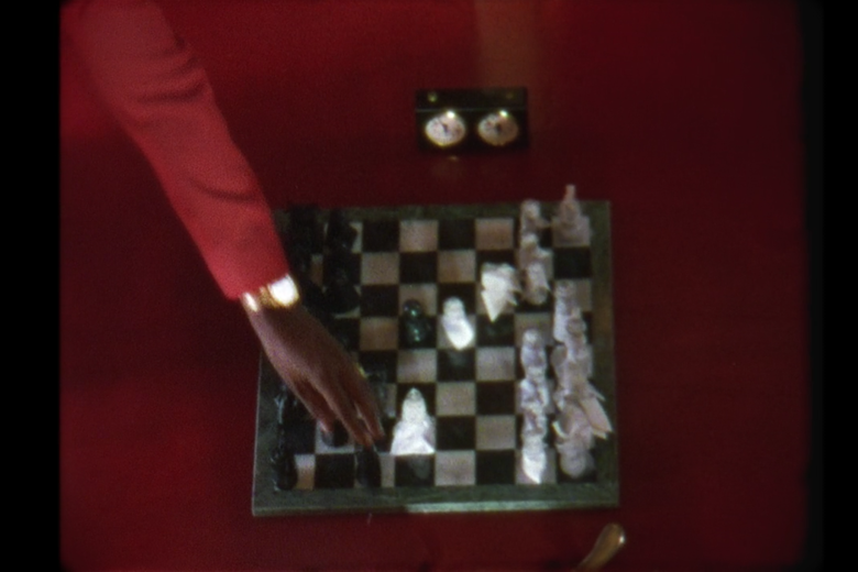 Jay-Z's hand moves a pawn on a class=