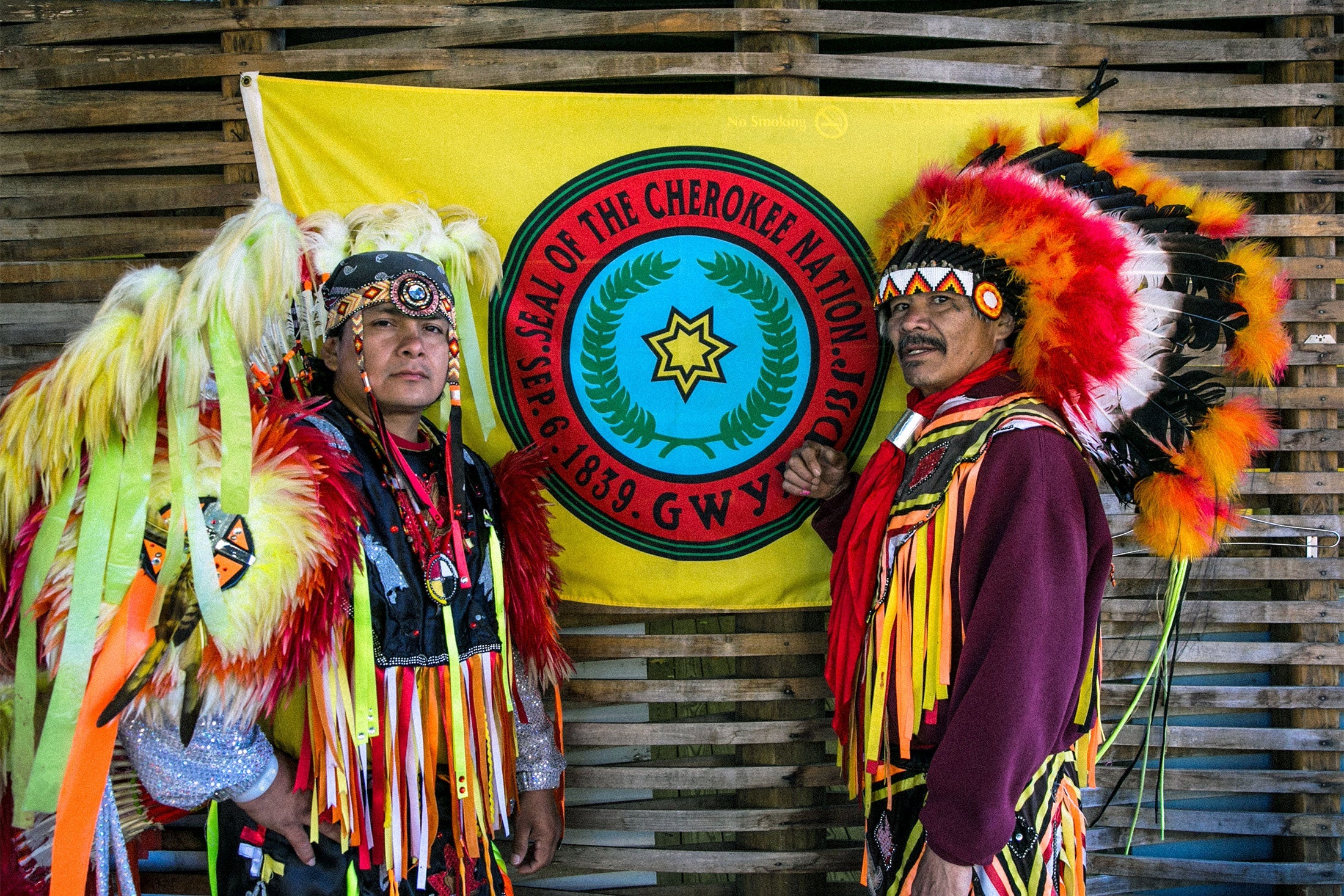 Two Cherokee Native American dancers pose for pictures along the highway on October 22, 2016 in Cherokee, North Carolina.