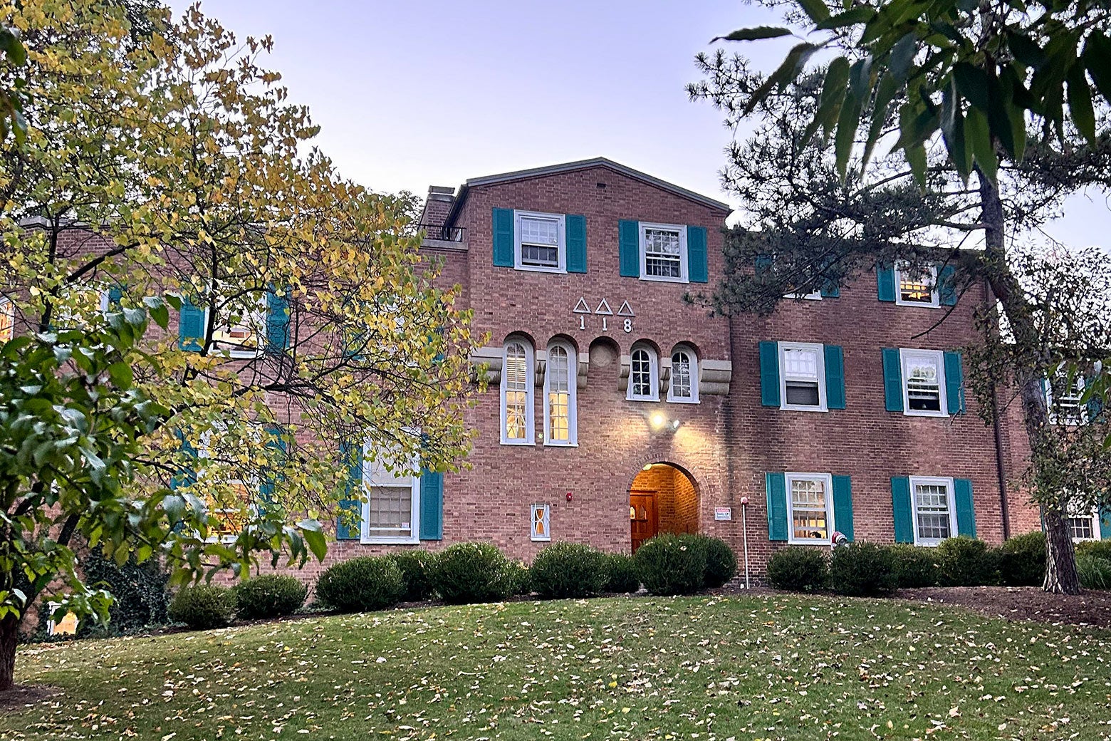 A brick building with green shutters.