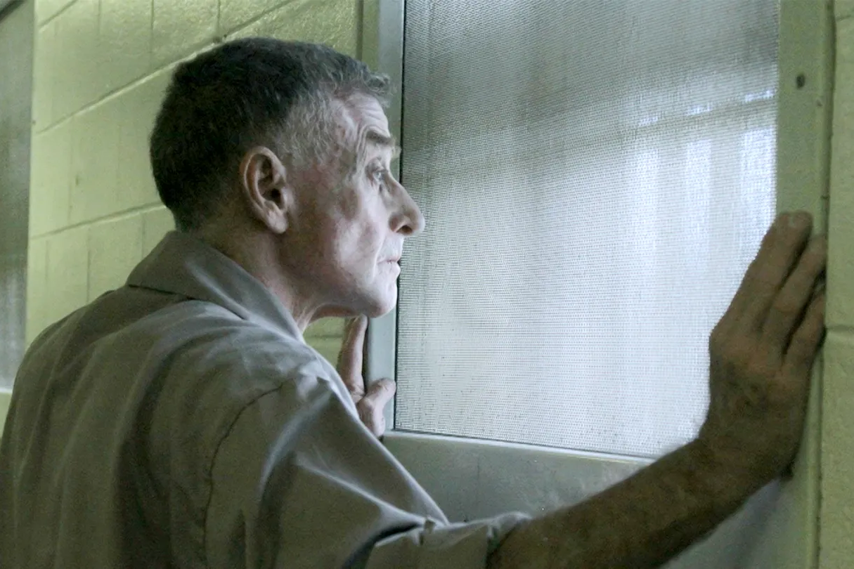 Man looking out from his prison cell.