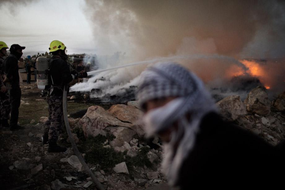 Palestinian fire fighters battle flames that erupted in a Bedouin encampment during clashes between Palestinian stone throwers and Israeli security forces in the West Bank village of Anata on March 8, 2013.