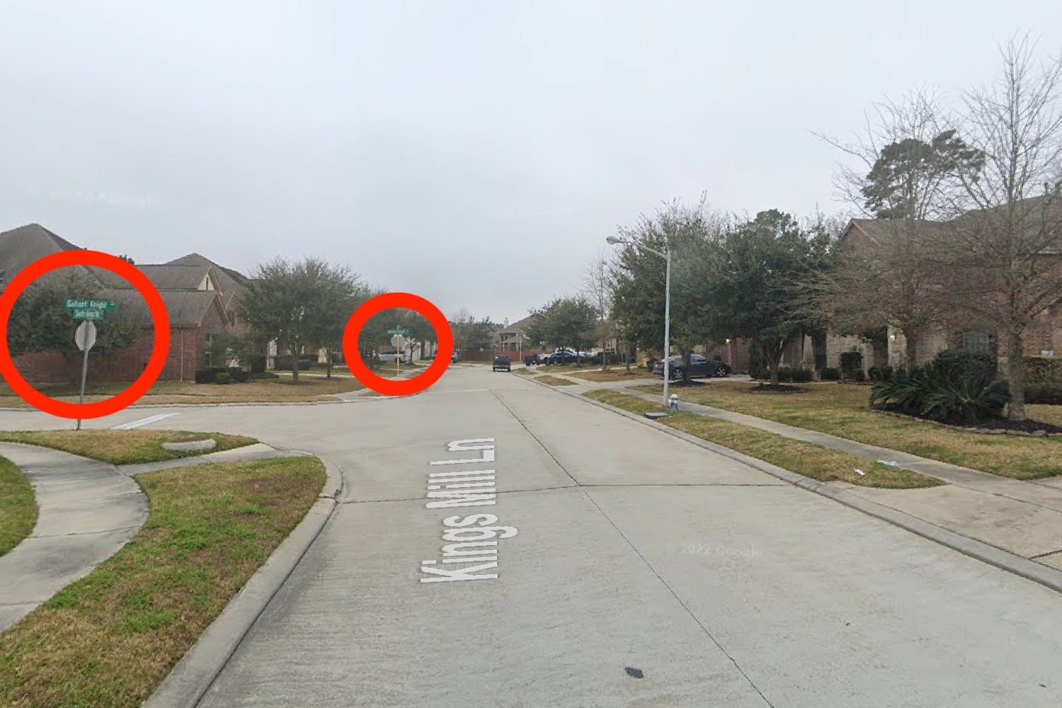 The intersection from the east, with two stop signs circled in red.
