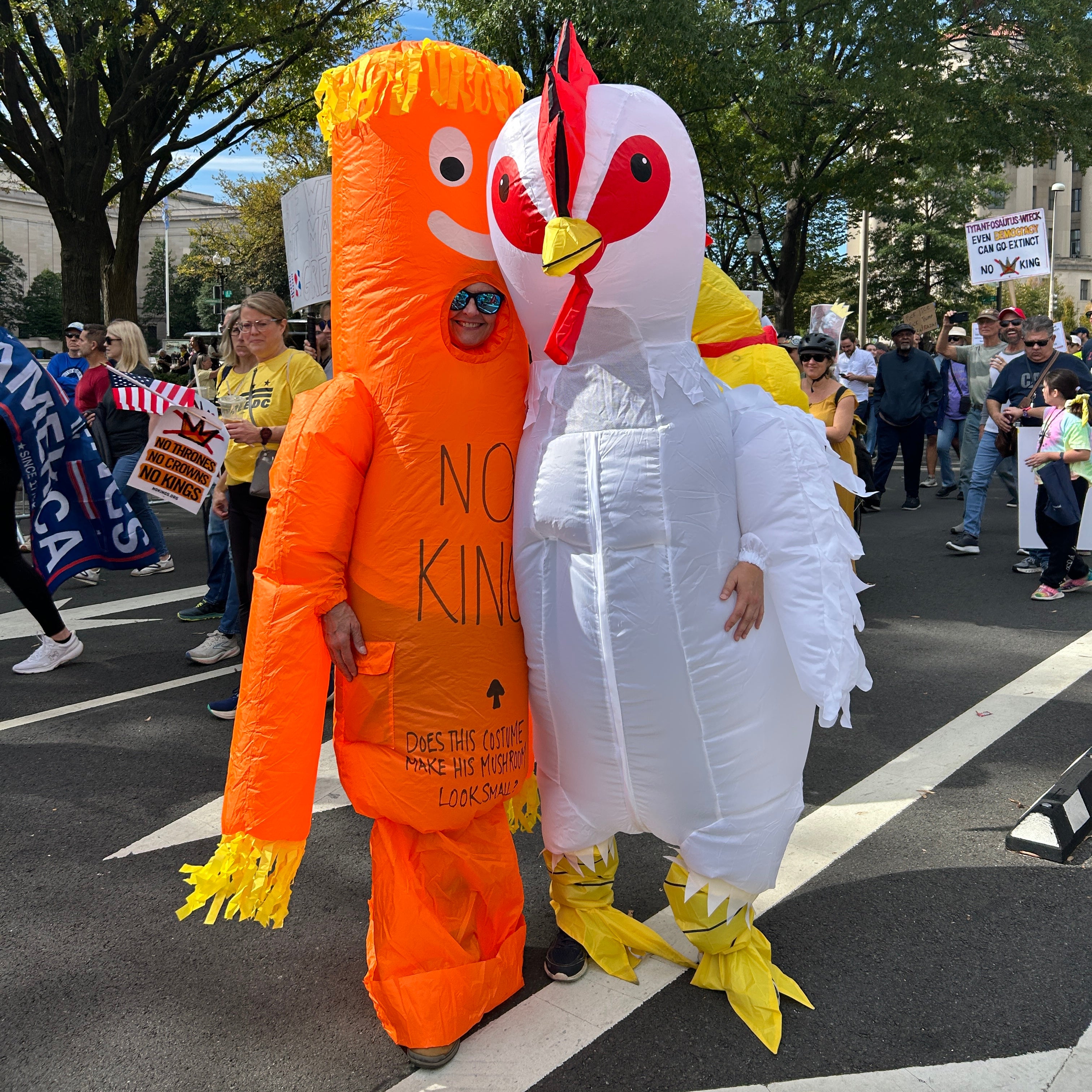 An inflatable chicken and an orange inflatable gumby-like creature with their arms around each other