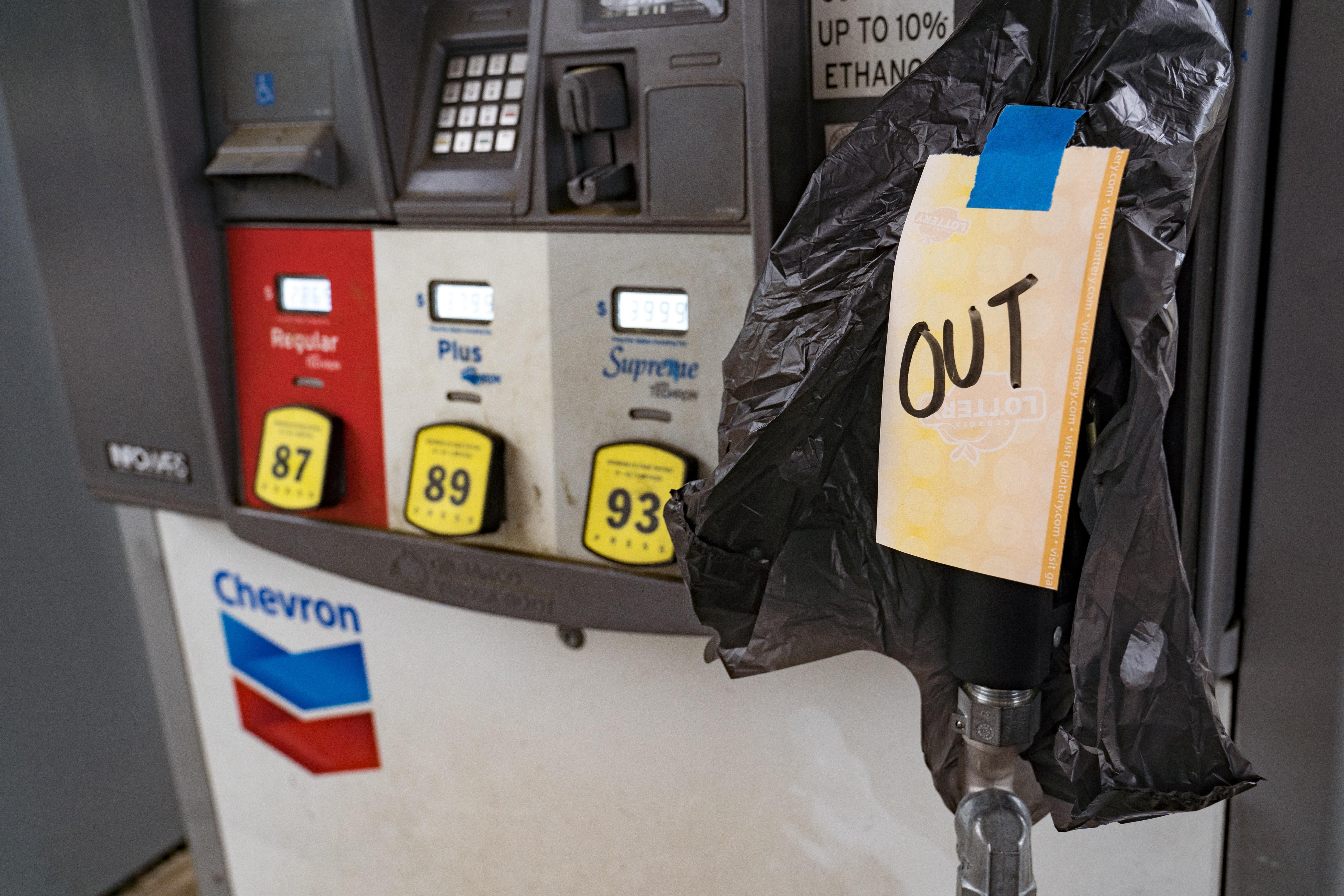 At a gas pump, the handle is covered with a trash bag that says "OUT."