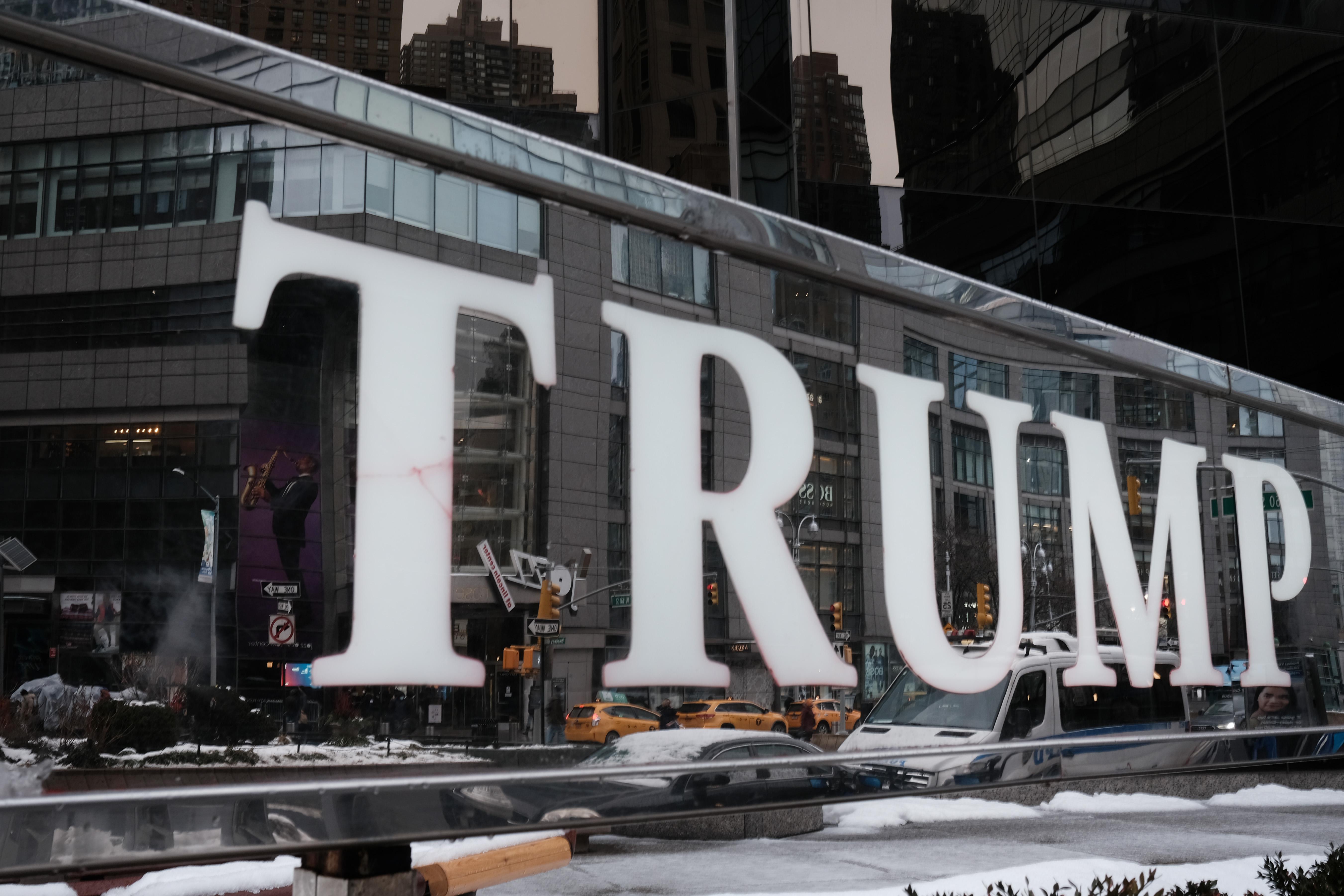 "Trump" in big letters on a mirrored sign reflecting a snowy day in New York