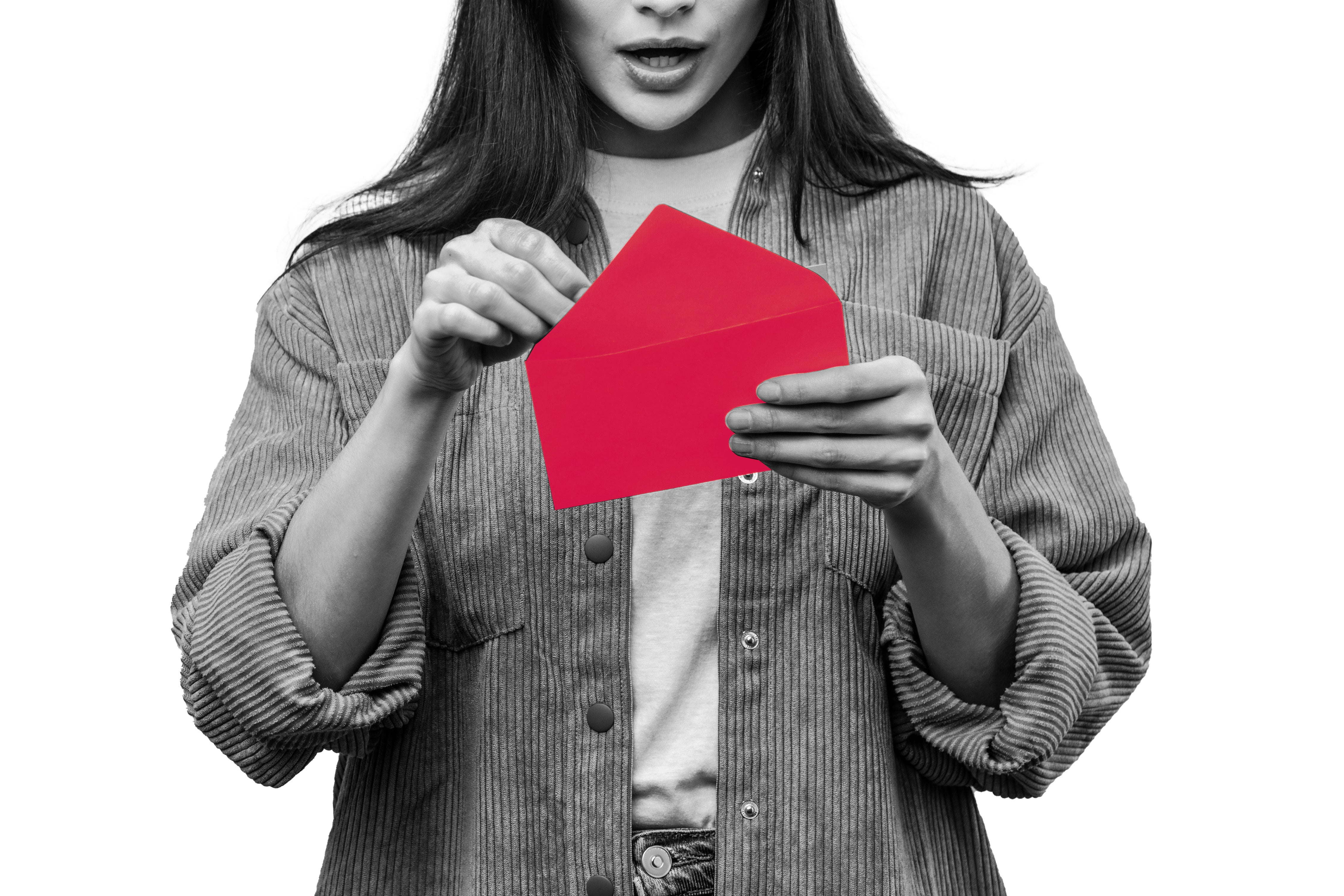 Woman looks inside of a red envelope