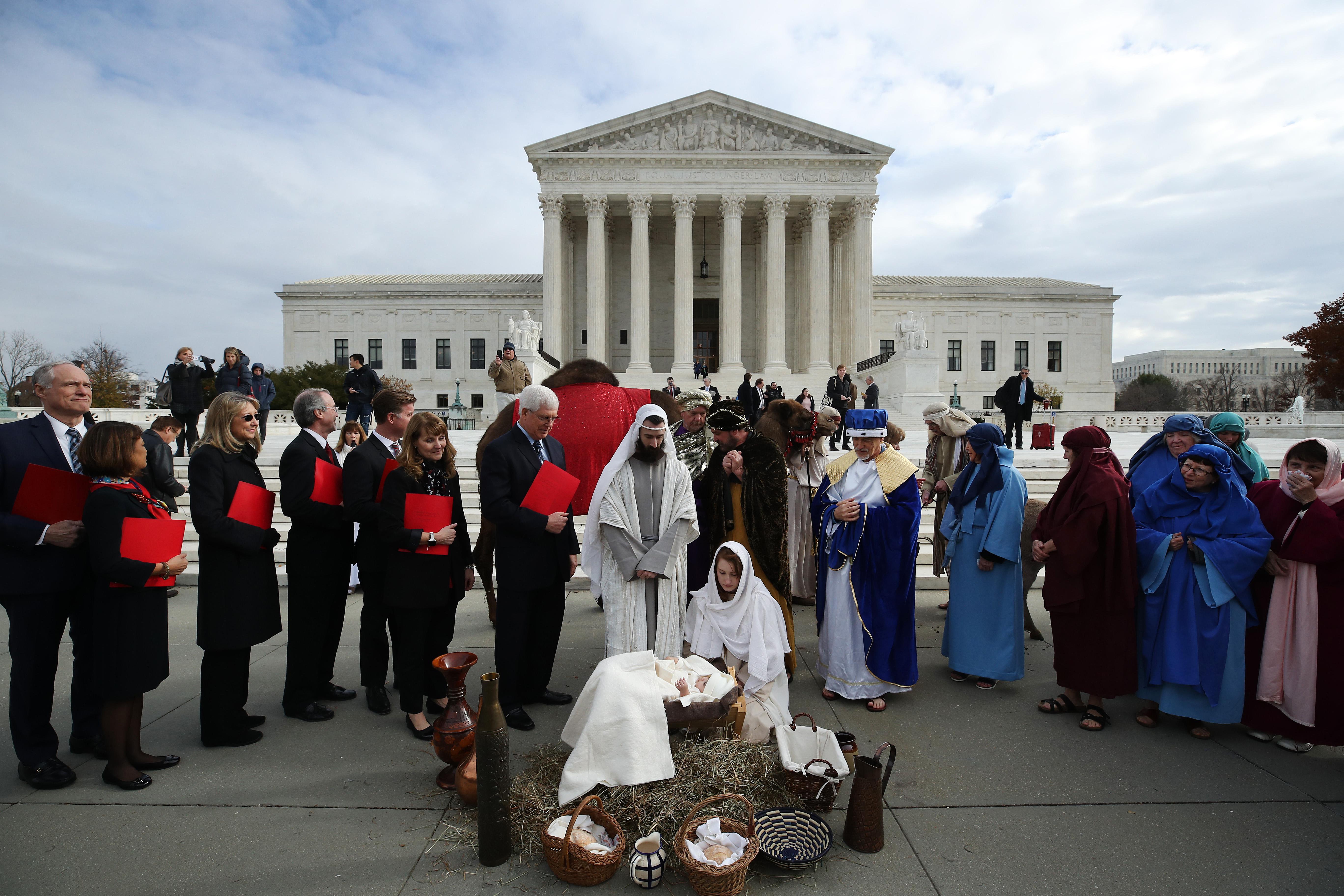 Actors portraying Jesus and Mary stage a nativity scene on the sidewalk in front of the Supreme Court.