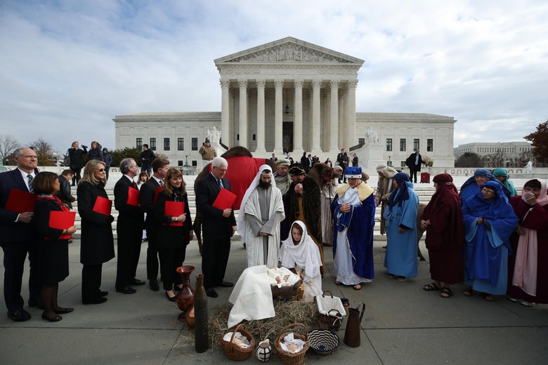 Actors portraying Jesus and Mary stage a nativity scene on the sidewalk in front of the Supreme Court.