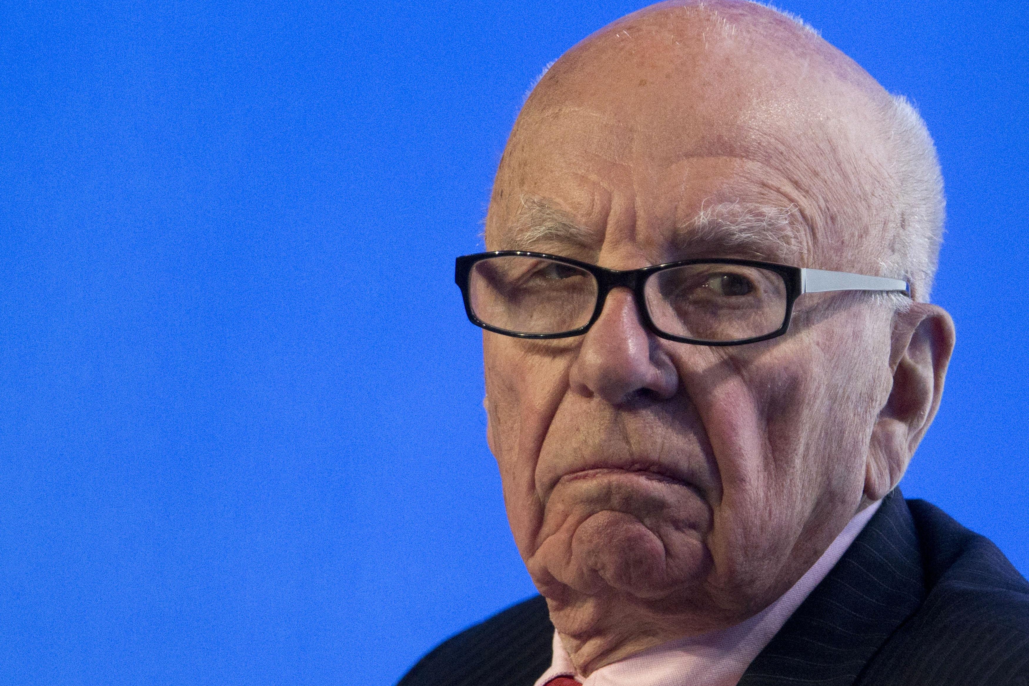 A close-up shot of Rupert Murdoch looking glum against a blue background.