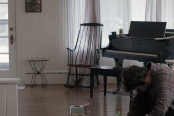 A living room with a rocking chair and a piano in it.
