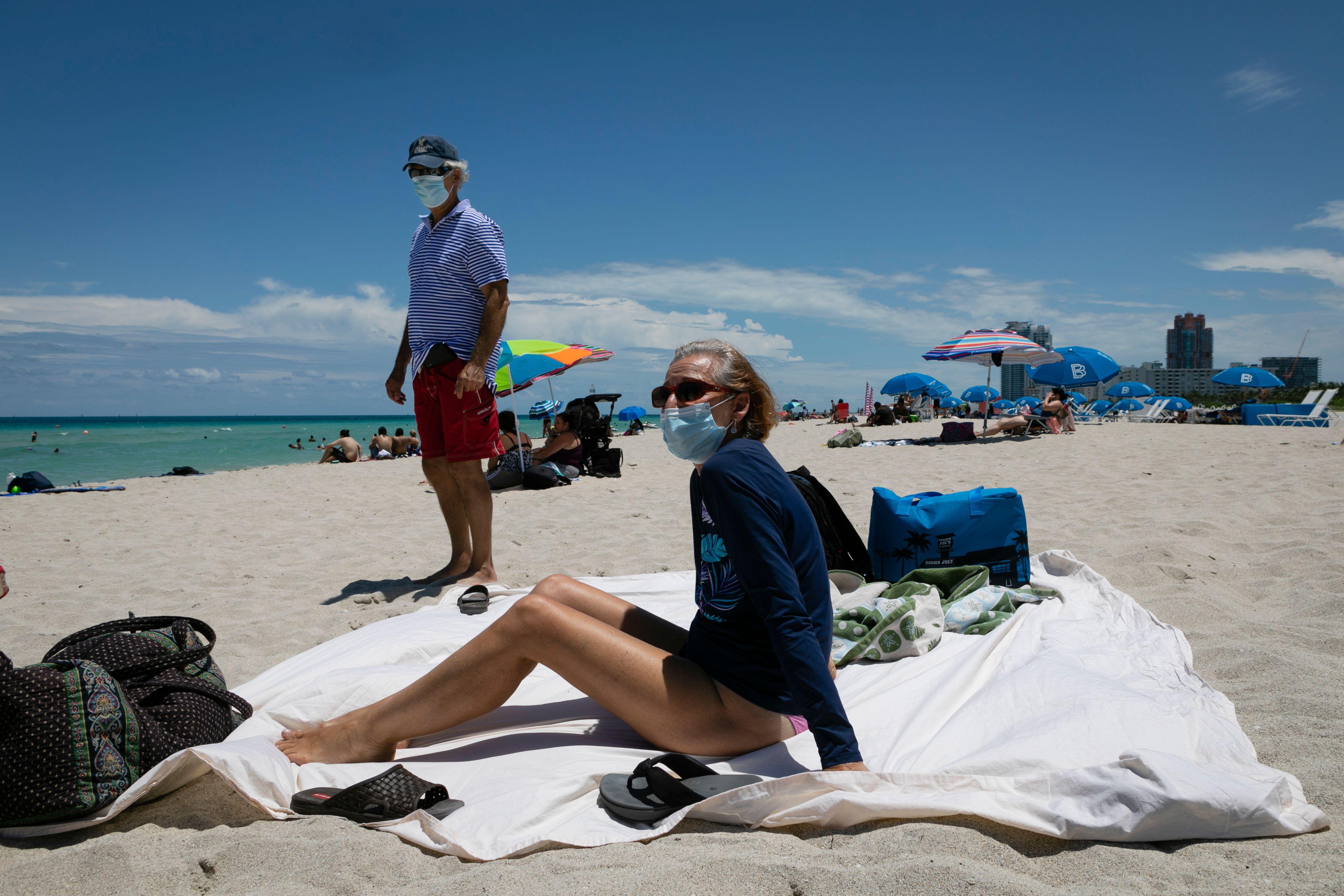 a woman on a beach blanket with a mask