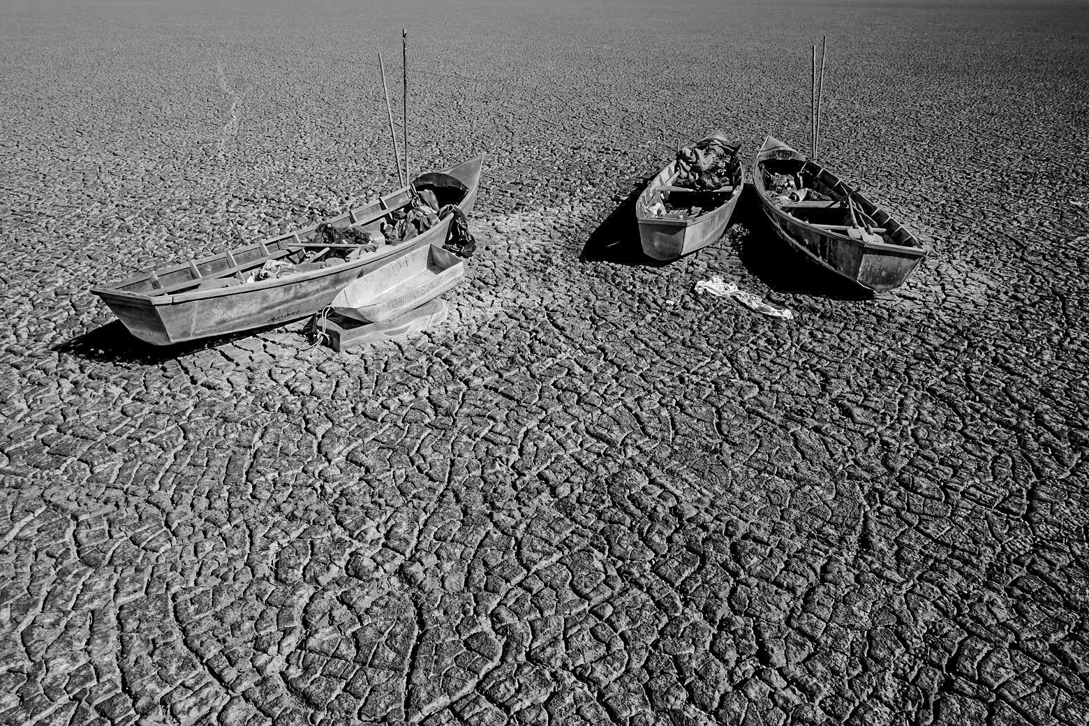 Boats of fishermen are seen on the dried Poopo lakebed in the Oruro Department, south of La Paz, Bolivia, December 17, 2015. Lake Poopo in Bolivia, the Andean nation's formerly second largest after the famed Titicaca, has dried up entirely. With the water now gone, animals have died off in the millions, according to studies. And the local families, having lost much of their sustenance, have been forced to migrate. REUTERS/David Mercado