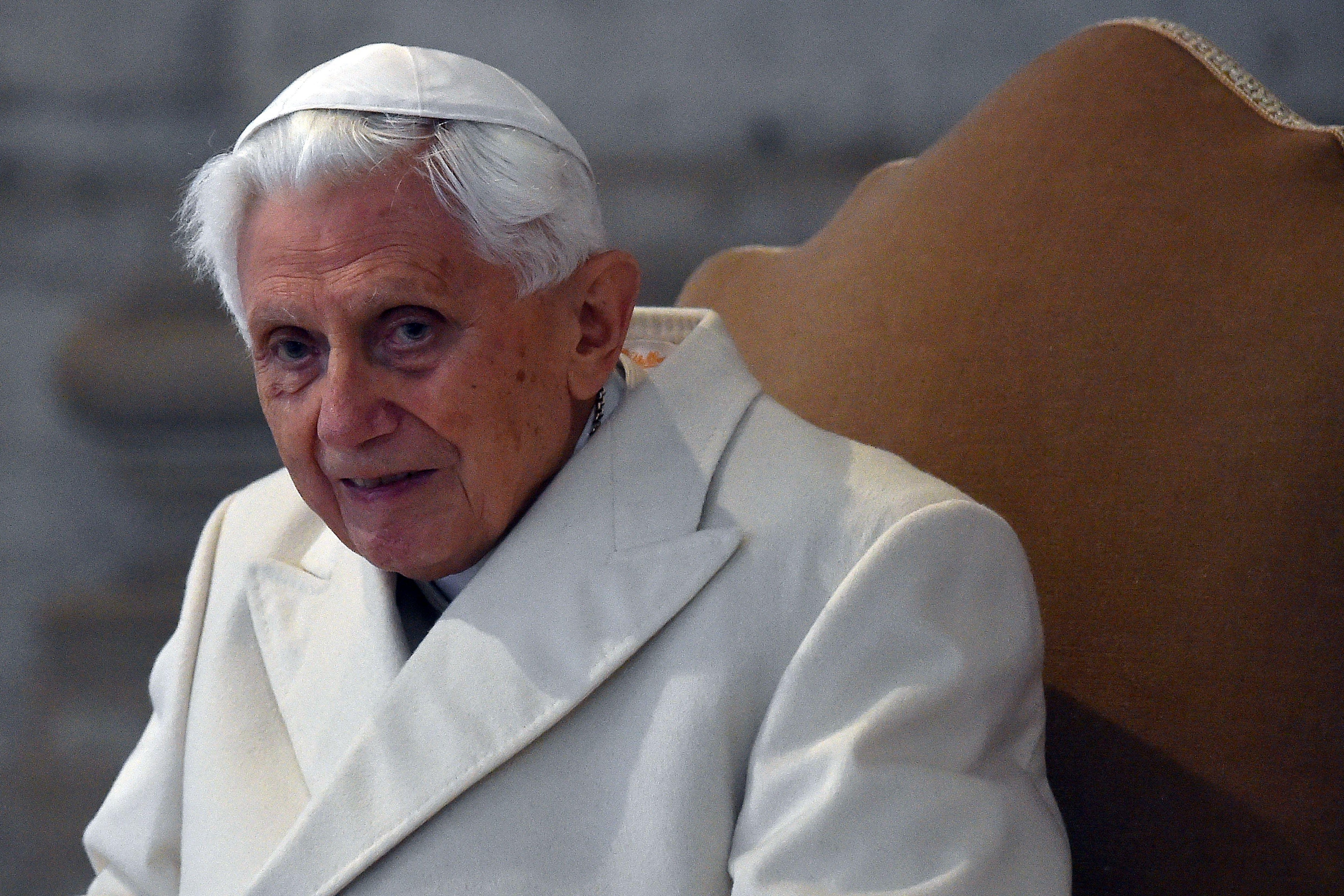 Pope Benedict seated in a white cap and white coat.