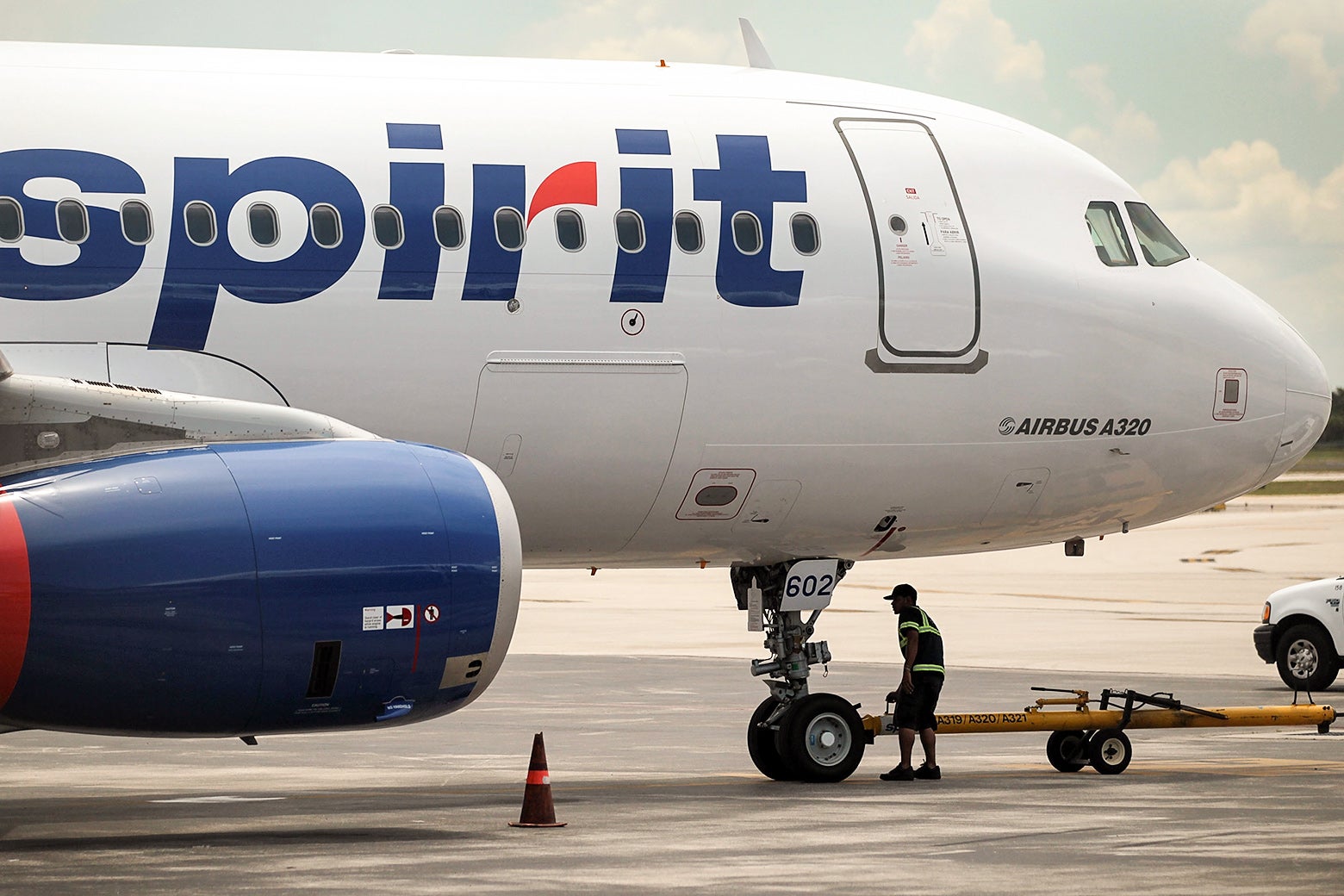 An employee walks under a recently landed Spirit plane.